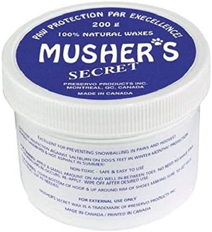 Applying Musher's Secret paw wax to a dog's paws